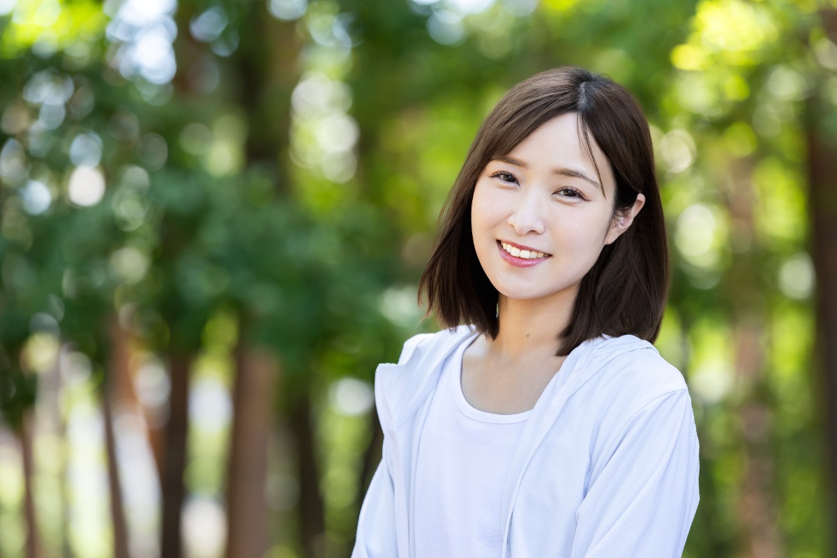 ホワイトニングをした白い歯でほほ笑む女性