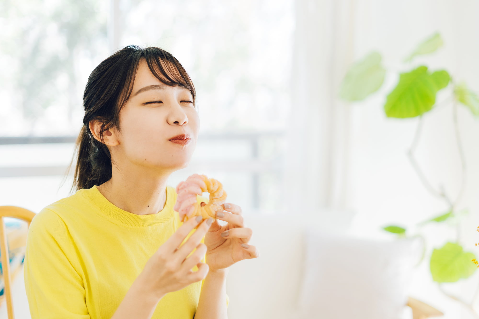 甘いドーナツを食べる女性