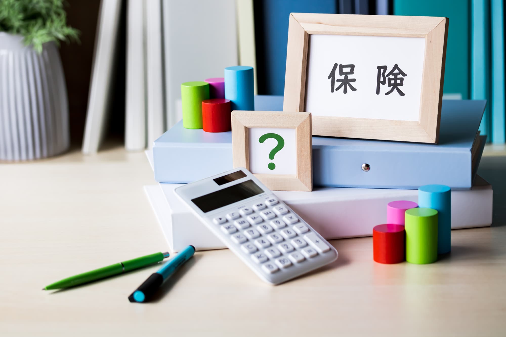 保険の文字とハテナマークと計算機