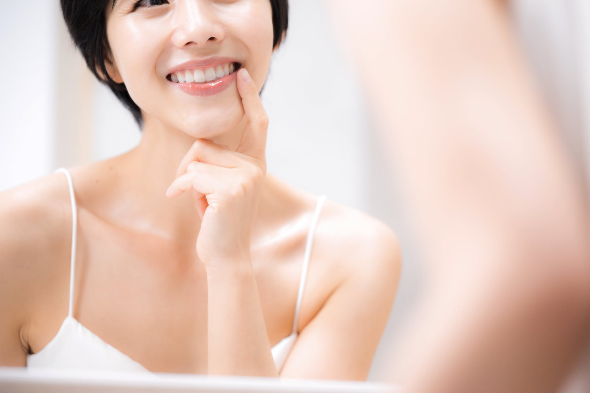 綺麗になった歯を鏡で確認して嬉しそうに笑う女性